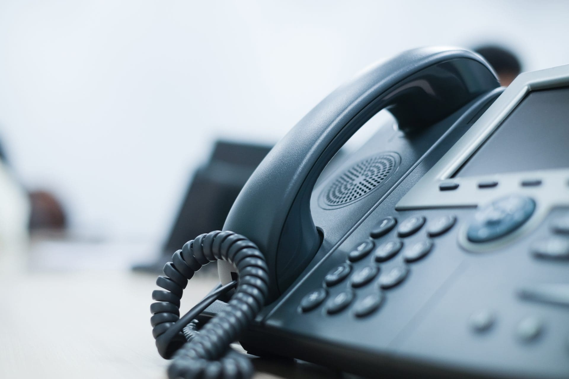 Close-up of a desktop telephone handset on an office desk.